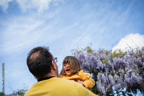 Laughing baby in yellow clothes play with father