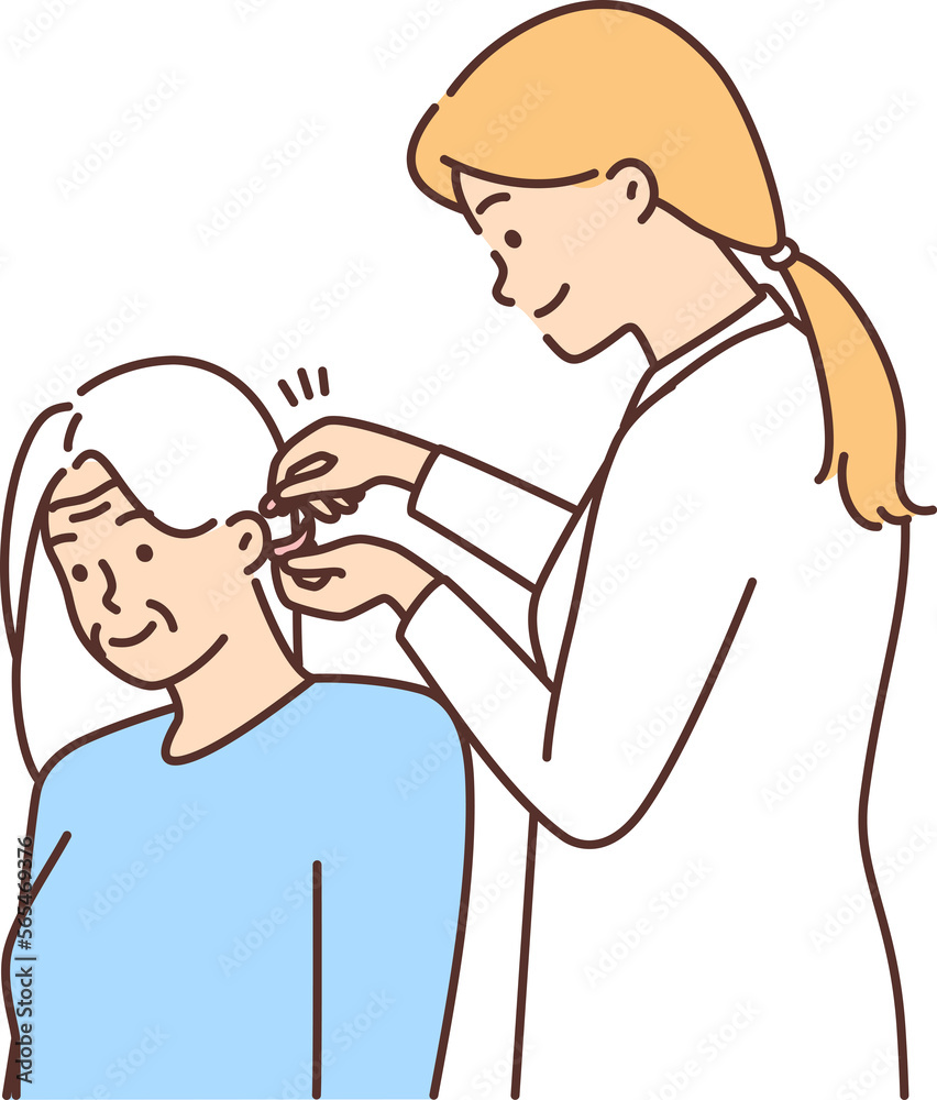 Female doctor install hearing aid to old patient