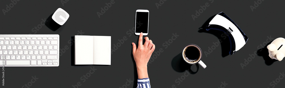 Person using a smartphone with other digital devices Person using a smartphone with other digital devices