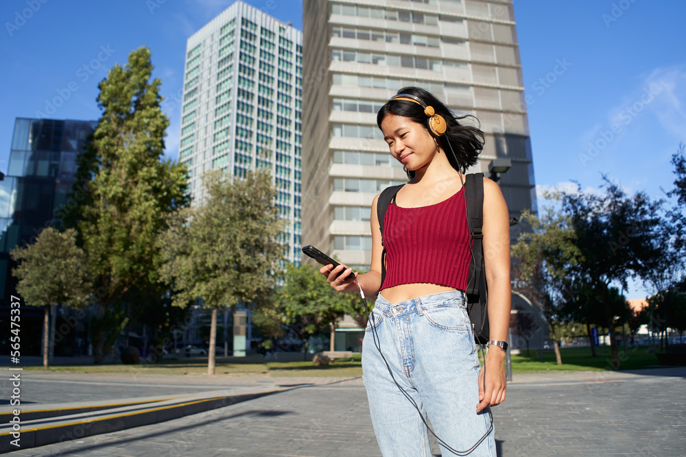 Fototapeta premium Young beautiful asian woman using smart phone and headphones. High quality photo