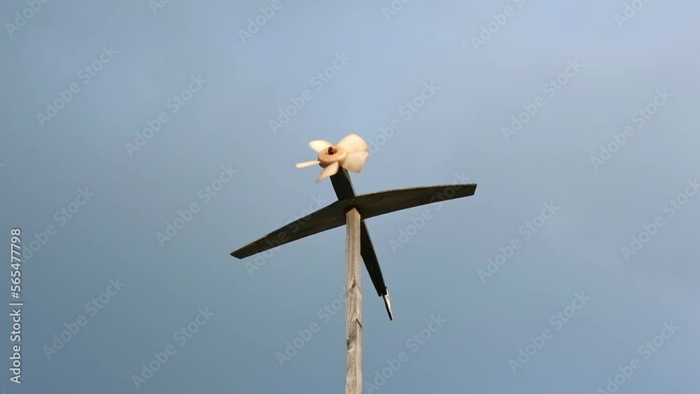 A homemade weather vane turns and shows the strength and direction of the wind. A weather vane