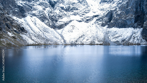 Czarny Staw pod Rysamy or Black Pond lake near the Morskie Oko Snowy Mountain Hut in Polish Tatry mountains, drone view, Zakopane, Poland. Aerial view shot of beautiful green hills and mountains in