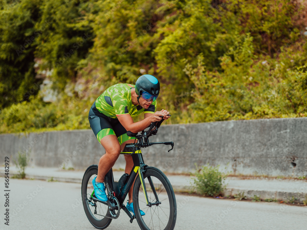 Full length portrait of an active triathlete in sportswear and with a protective helmet riding a bicycle. Selective focus Full length portrait of an active triathlete in sportswear and with a protective helmet riding a bicycle. Selective focus