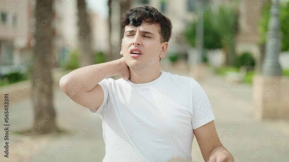 Non binary man using handfan suffering for hot at park Non binary man using handfan suffering for hot at park