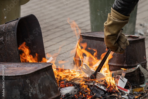 Fotografie A technician wearing fire resistant gloves places raku ware into a reduction fir