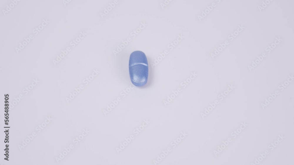 Blue color pill rotate on white background Macro frame Healthcare. Medicines, pills. 4K Top view Blue color pill rotate on white background Macro frame Healthcare. Medicines, pills. 4K Top view