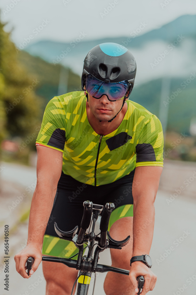 Full length portrait of an active triathlete in sportswear and with a protective helmet riding a bicycle. Selective focus Full length portrait of an active triathlete in sportswear and with a protective helmet riding a bicycle. Selective focus