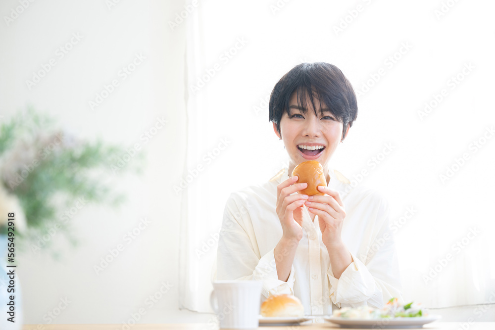 And for the main visual! Woman eating bread Beautiful fresh breakfast scene with the morning sun Looking at the camera And for the main visual! Woman eating bread Beautiful fresh breakfast scene with the morning sun Looking at the camera