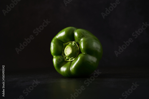 Green bell pepper isolated against a black background. Vegetables artfully presented. Close up of a nutritious paprika. 