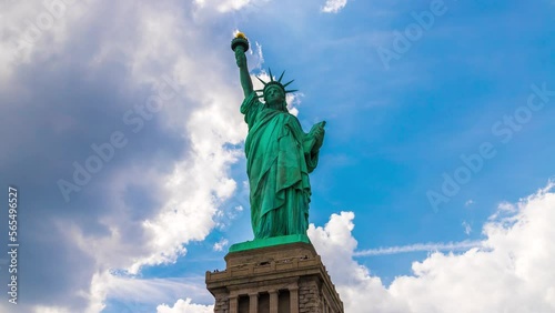 Uhd 4k Timelapse of  Statue of Liberty against blue sky with beautiful cloud background in New York City, NY, USA
