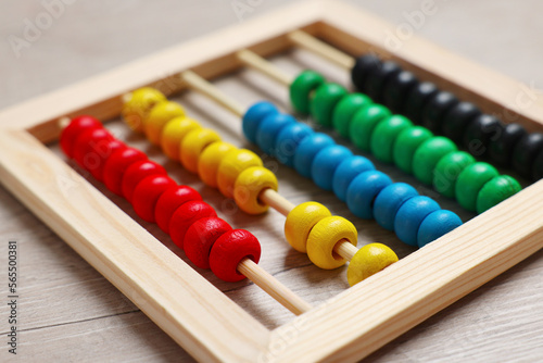 Colorful toy abacus on white wooden table  closeup. Funny math game