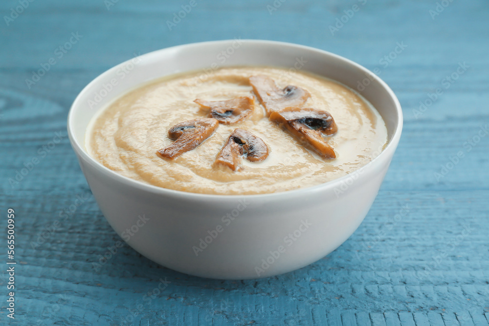 Delicious mushroom cream soup on light grey wooden table, closeup Delicious mushroom cream soup on light grey wooden table, closeup