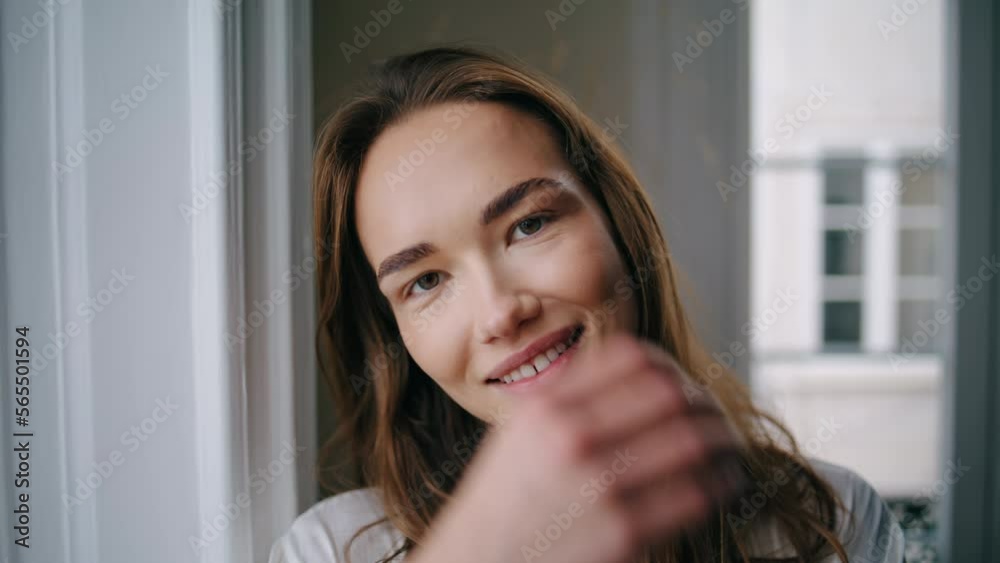Cheerful woman smiling camera at home portrait. Positive girl playing hair Cheerful woman smiling camera at home portrait. Positive girl playing hair