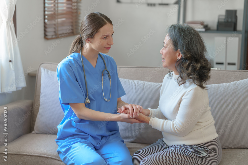 Obraz premium Portrait of attractive young caucasian female nurse elderly caregivers with senior patient home caring for elderly asia female patients on couch, indoors. hand clasp to encourage