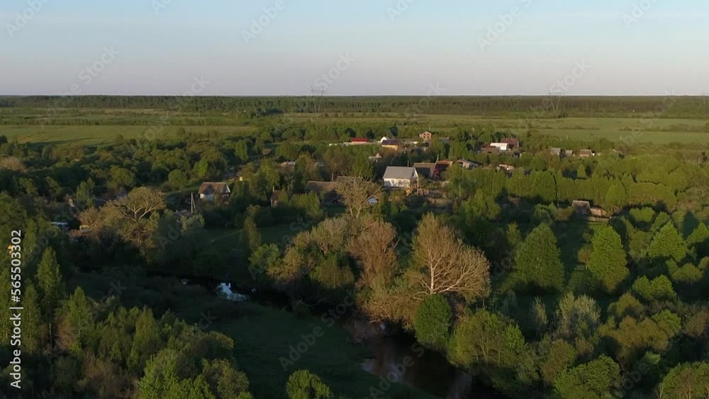 Aerial view panorama of Village with houses and gardens on a river surrounded by green field with stunning landscape cinematic views. Concept climate outdoor nature. Aerial view panorama of Village with houses and gardens on a river surrounded by green field with stunning landscape cinematic views. Concept climate outdoor nature.
