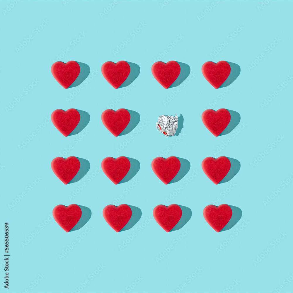 Trendy love composition made of Red heart chocolates on blue background. Minimal concept of Valentine's Day or love. Creative art, minimal aesthetics. Top view. Flat lay