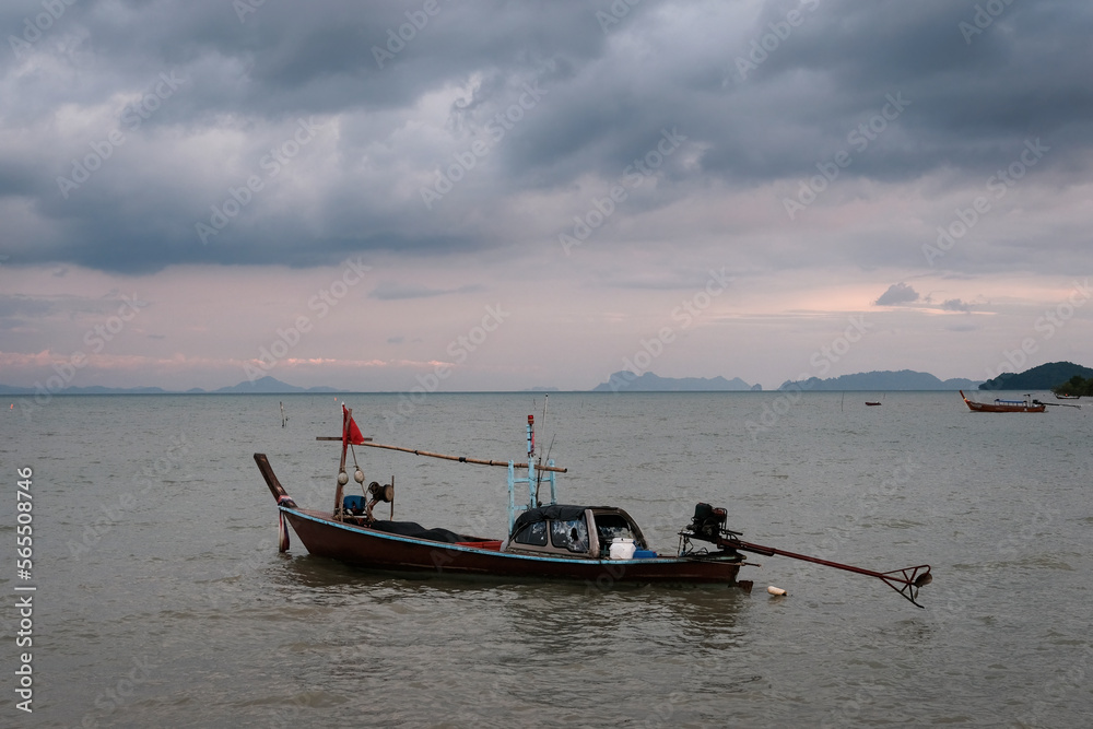 Traditional thai longtail boat on dramatic cloudy evening. Ko Lanta Old Town, Thailand.