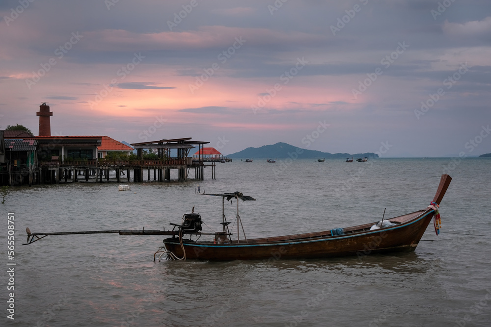 Traditional thai longtail boat and Ko Lanta Old Town at sunset, Thailand.