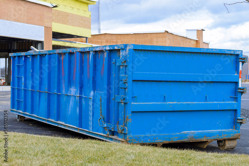blue dumpster, bin near new construction site of apartment houses building
