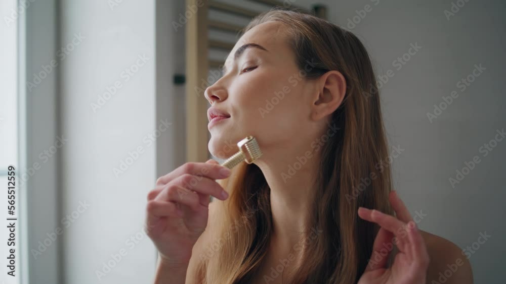Young lady massaging face in bath room portrait. Fresh girl using jade roller Young lady massaging face in bath room portrait. Fresh girl using jade roller