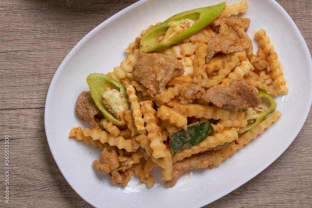 Stir-fried pork with red curry paste and young coconut shoots in a white plate Stir-fried pork with red curry paste and young coconut shoots in a white plate