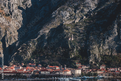 Kotor, Montenegro, beautiful top panoramic view of Kotor city old medieval town seen from San Giovanni St. John Fortress, with Adriatic sea, bay of Kotor and Dinaric Alps mountains in a sunny day photo