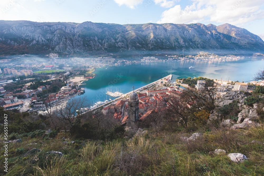 Obraz premium Kotor, Montenegro, beautiful top panoramic view of Kotor city old medieval town seen from San Giovanni St. John Fortress, with Adriatic sea, bay of Kotor and Dinaric Alps mountains in a sunny day
