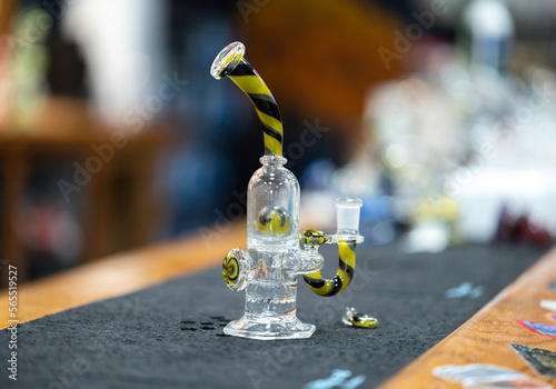 a closeup of a yellow and black glass bong used for recreational cannabis