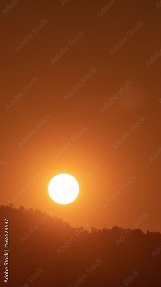 Timelapse of dramatic sunrise with orange sky in a sunny day.