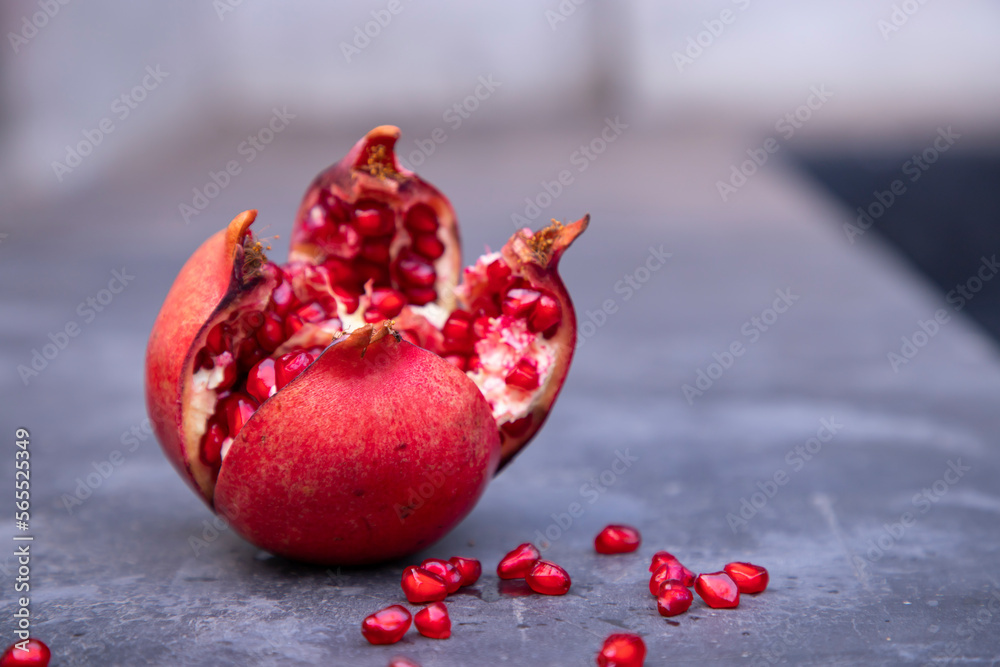 ripe pomegranate fruit with seeds on a gray background ripe pomegranate fruit with seeds on a gray background