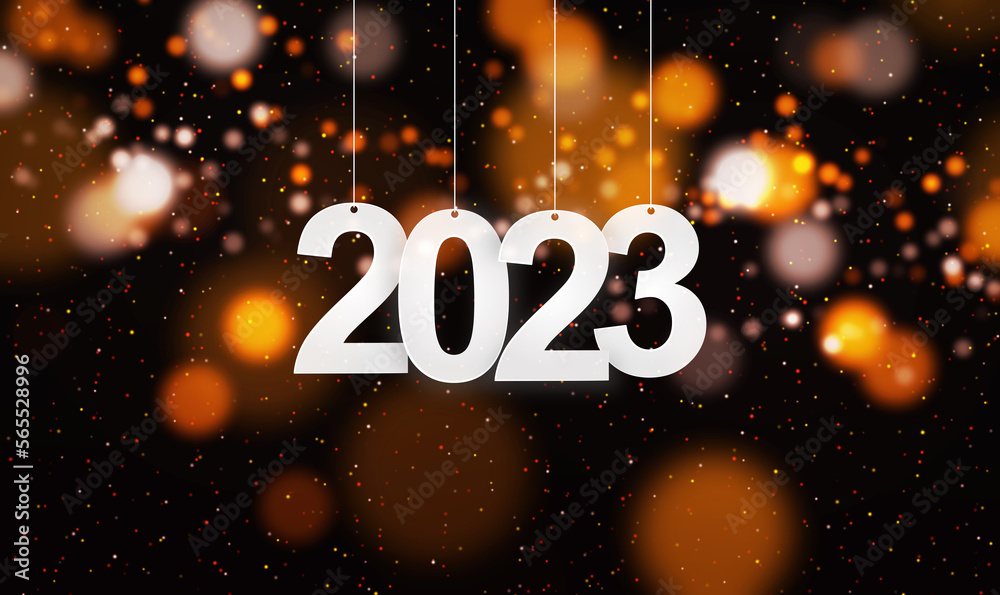 Happy New Year 2023 with small glitters sprinkling down. Hanging white paper cut number with festive confetti on an orange golden blurry bokeh background.