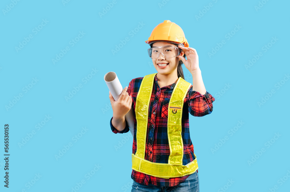 Young female engineer wearing yellow helmet hold blueprint posture