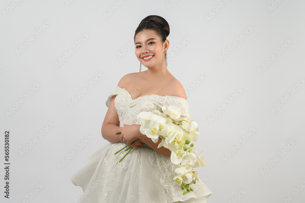 Young asian beautiful bride with orchid bouquet on white background Young asian beautiful bride with orchid bouquet on white background
