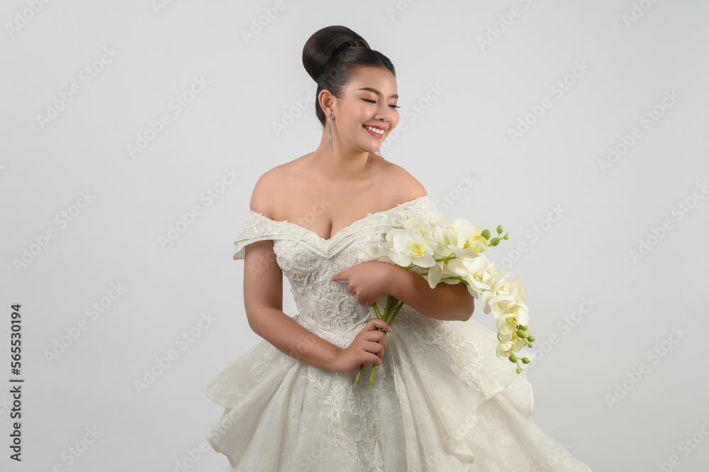 Young asian beautiful bride with orchid bouquet on white background Young asian beautiful bride with orchid bouquet on white background