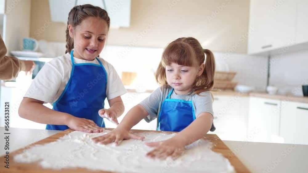 children making dough in the kitchen. two little girls cook in the kitchen knead dough and flour indoors. happy family kid dream concept. children play cooking dough together at home fun children making dough in the kitchen. two little girls cook in the kitchen knead dough and flour indoors. happy family kid dream concept. children play cooking dough together at home fun