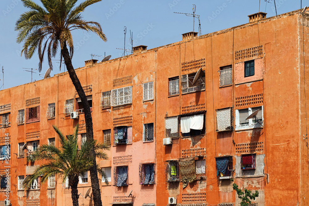 Naklejka premium View of the red walls shabby residential buildings in Marrakech on a sunny day. Morocco.