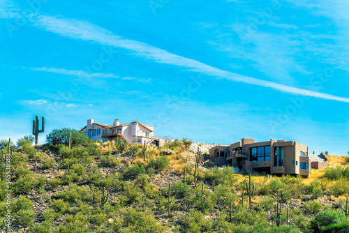 Houses on a hillside ridge in the sonora desert of Arizona with visble cactus and sprawling natural grasses and vegitation photo