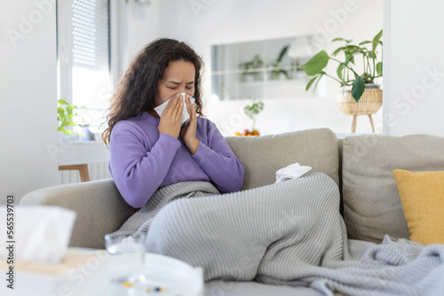 Sick desperate woman has flu. Rhinitis, cold, sickness, allergy concept. Asian sick woman has runnning nose, rubs nose with handkerchief. Sneezing female. Brunette sneezing in a tissue