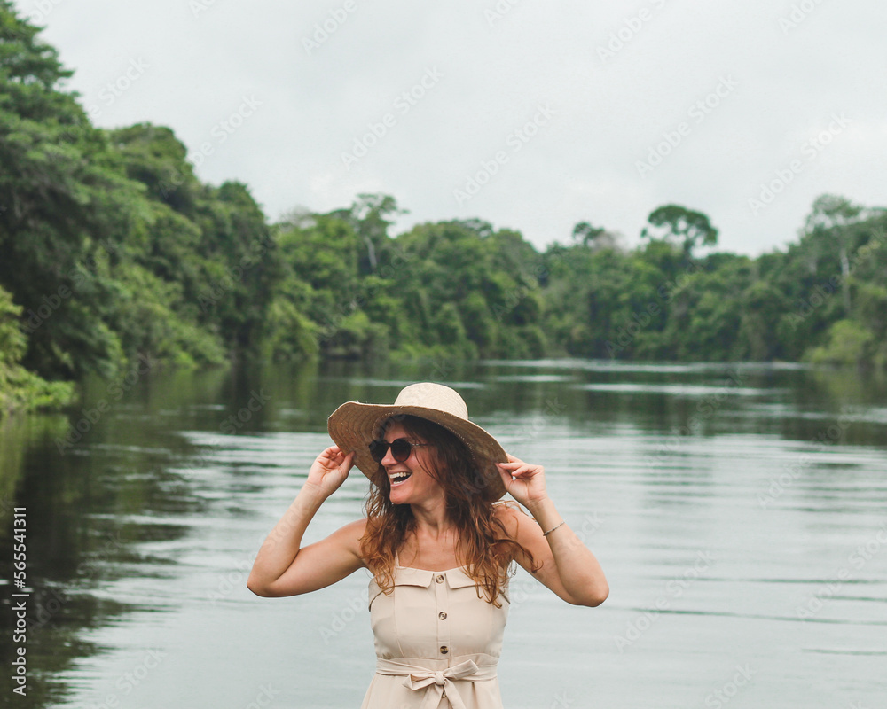 Mulher de chapéu na beira do rio cristalino, em alta floresta, mato grosso, no sul da amazonia brasileira 
