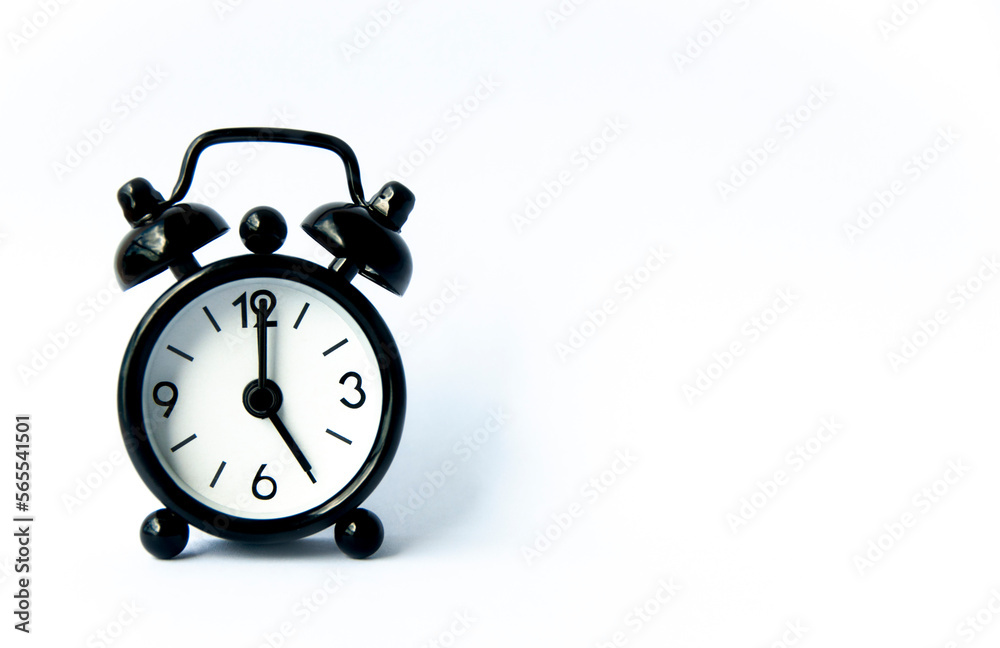 Black alarm clock pointing at 5 o'clock with customizable space for text on white background. Copy space and time concept.