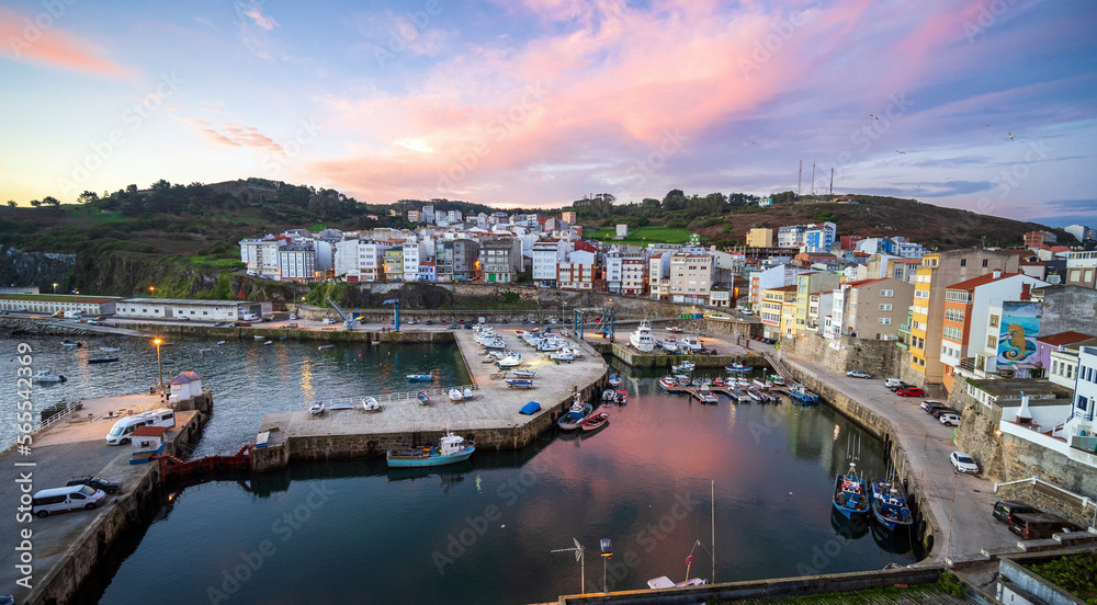 Malpica, Spain harbor at sunrise with pink clouds and fishing boats