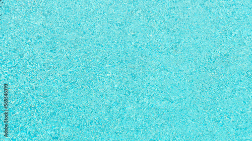 Background of swimming poll surface with ripple and sun reflections, top view water texture.