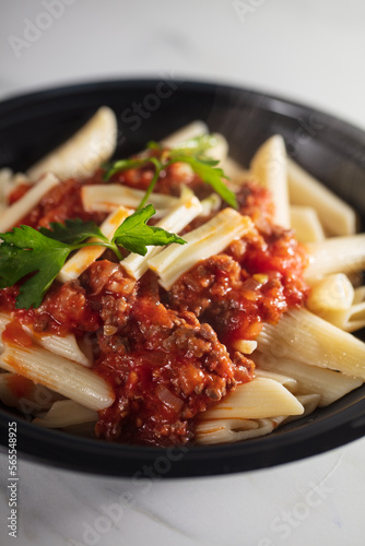 Pasta Penne with Tomato Bolognese Sauce  Parmesan Cheese and Basil. . High quality photo