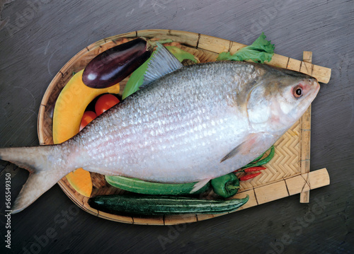 fresh hilsa fish on a wooden board with vegetable 