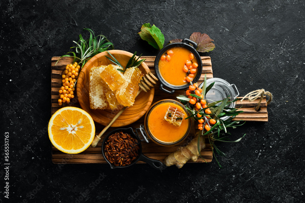 Autumn menu concept. Honey, sea buckthorn and citrus fruits. On a dark background. Top view. Autumn menu concept. Honey, sea buckthorn and citrus fruits. On a dark background. Top view.