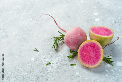 Sliced radish watermelon on the kitchen stone table, diet food. Free space for text, on stone background. © Yaruniv-Studio
