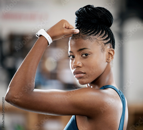 Portrait, fitness or black woman with strong biceps muscle or body goals in training, workout or exercise at gym. Face, results or healthy African girl sports athlete with power, motivation or focus