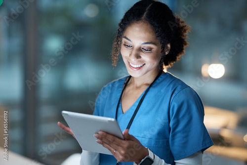 Nurse, medical tablet and black woman in hospital working late on telehealth, research or online consultation. Tech, healthcare or female physician with technology for wellness app in clinic at night photo
