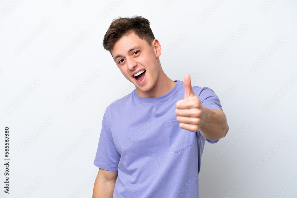 Young handsome Brazilian man isolated on white background with thumbs up because something good has happened Young handsome Brazilian man isolated on white background with thumbs up because something good has happened