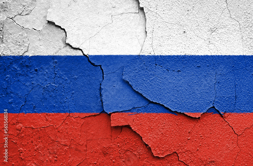 Flag of Russia painted on a craced wall. Embargo and sanctions for military aggression.  photo